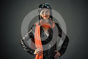 Smiling woman pilot in red scarf in aviator helmet