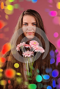 smiling woman with pink flowers. Studio pink background