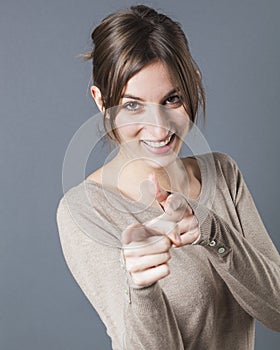 Smiling woman pointing her fingers in foreground to accuse someone guilty photo