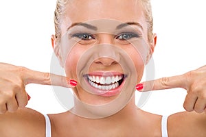 Smiling woman pointing in her perfect teeth