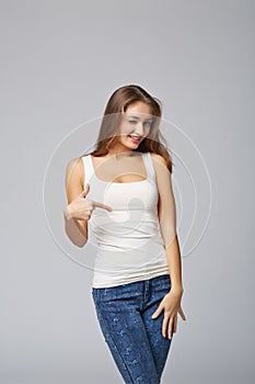 Smiling woman pointing at herself cheering happy, on gray background