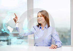 Smiling woman pointing to earth hologram