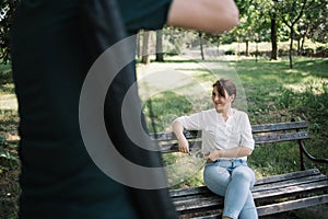 Smiling woman posing while cropped man taking photos of her