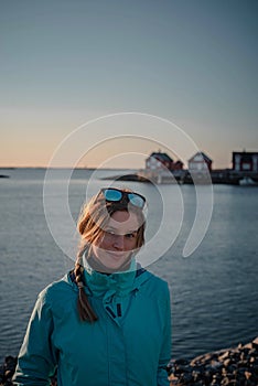 Smiling woman posing in front of typical norwegian red houses during a spring hike.