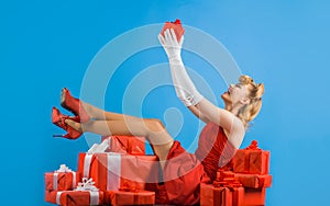 Smiling woman with present. Happy girl in red dress with gift. Valentines day, Womens day, birhtday.
