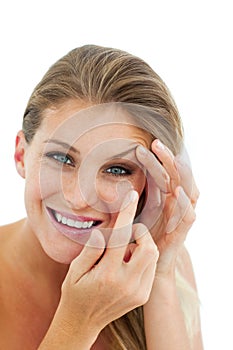 Smiling woman putting a contact lens