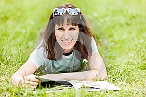 Smiling woman reading book outdoor