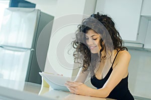 Smiling woman reading on digital tablet