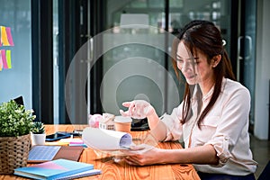 Smiling woman reading financial reports at her office room.