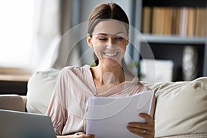 Smiling woman reading good news in paper letter or documents