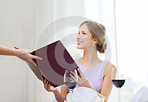 Smiling woman recieving menu from waiter