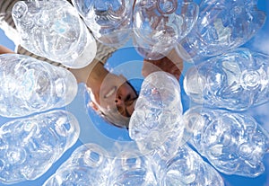 Smiling woman recycling plastic water bottles