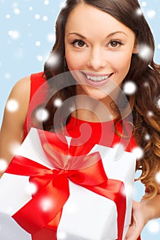 Smiling woman in red dress with gift box