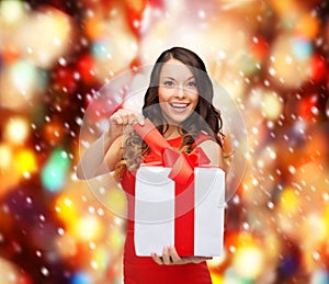 Smiling woman in red dress with gift box