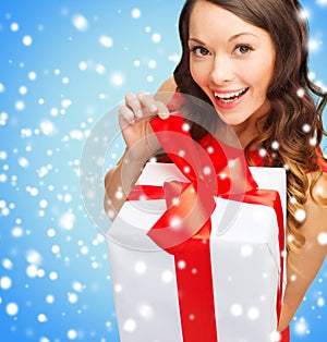 Smiling woman in red dress with gift box