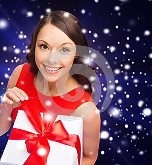 Smiling woman in red dress with gift box