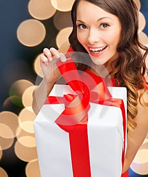 Smiling woman in red dress with gift box