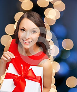 Smiling woman in red dress with gift box