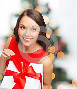 Smiling woman in red dress with gift box