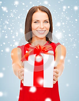 Smiling woman in red dress with gift box
