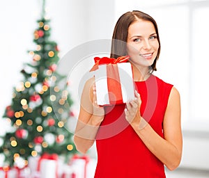 Smiling woman in red dress with gift box