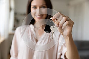 Smiling woman renter hold house keys in hands