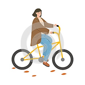 Smiling woman riding bicycle outdoors and enjoying life in autumn city