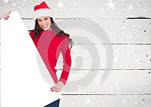 Smiling woman in santa hat holding blank placard