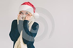 Smiling woman in Santa hat , isolated on white. The girl is dressed in sweater, christmas cap and scarf studio shot