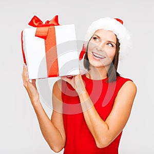 Smiling woman in santa helper hat with gift box