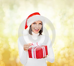 Smiling woman in santa helper hat with gift box