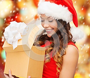 Smiling woman in santa helper hat with gift box