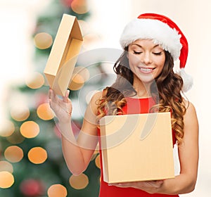 Smiling woman in santa helper hat with gift box