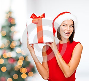 Smiling woman in santa helper hat with gift box