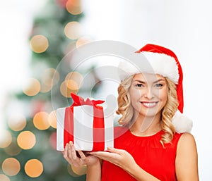 Smiling woman in santa helper hat with gift box