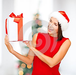 Smiling woman in santa helper hat with gift box