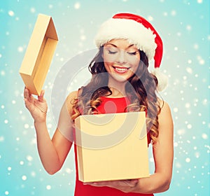 Smiling woman in santa helper hat with gift box