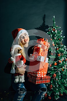 Smiling woman in santa helper hat with many gift boxes
