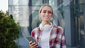 Smiling woman selects a track from her playlist while cherishing the music.