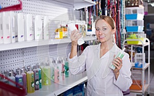 Smiling woman seller advising on pet shampoo