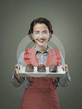 Smiling woman serving chocolate muffins
