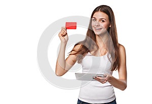 Smiling woman showing blank credit card hold tablet pc in hand, in white t-shirt, isolated over white background