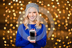 Smiling woman showing blank smartphone screen
