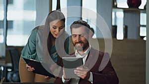 Smiling woman showing documents bearded realtor at comfortable lawyer cabinet