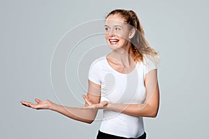 Smiling woman showing open hand palm with copy space