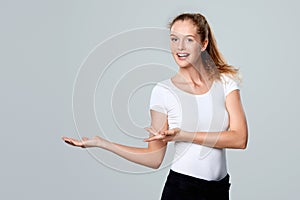 Smiling woman showing open hand palm with copy space