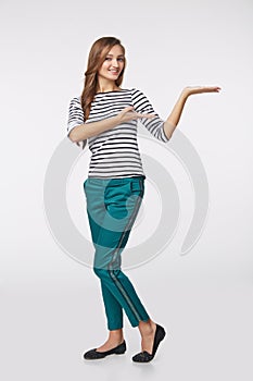 Smiling woman showing open hand palm with copy space for product