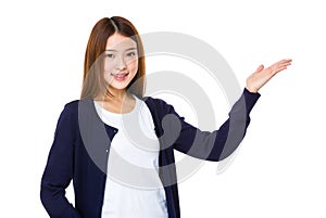 Smiling woman showing open hand palm with copy space for product