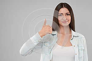 Smiling woman showing thumb up.