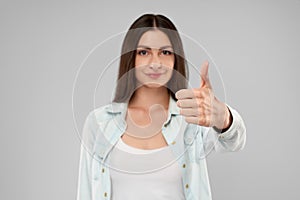 Smiling woman showing thumb up.